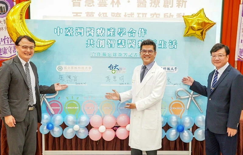 雲科大、臺大醫院雲林分院與虎科大醫療產學合作簽約活動，三名代表於「中臺灣醫療產學合作，共創智慧醫療新生活」背板前合影。