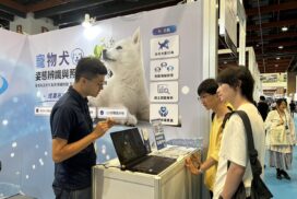 2026年AI展，展位人員向兩名參觀者介紹寵物犬姿態辨識與照護技術。